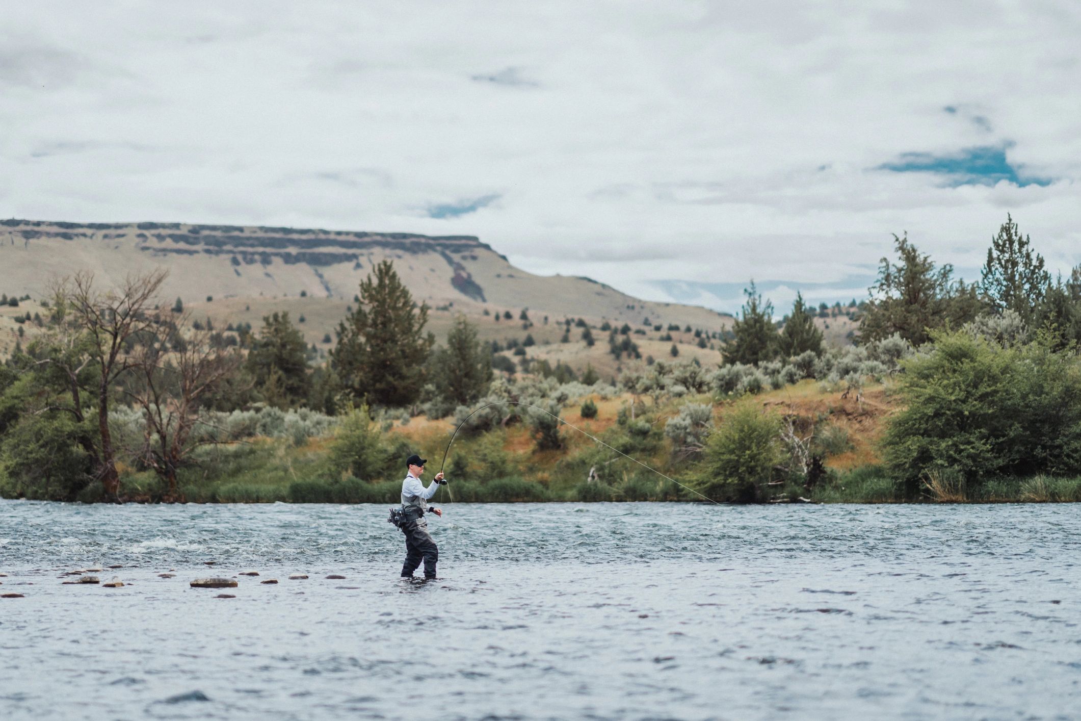 Fly fisherman wading in a river